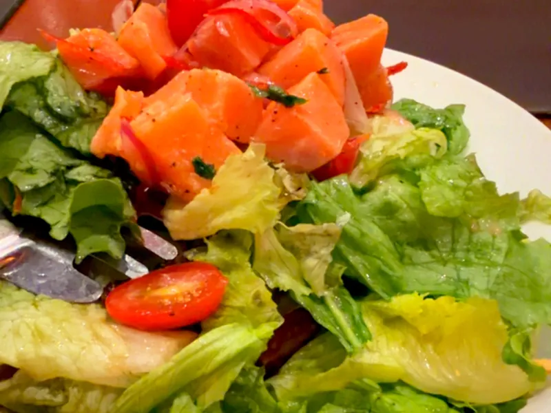 Salada com salmão em cubos, tomate e folhas