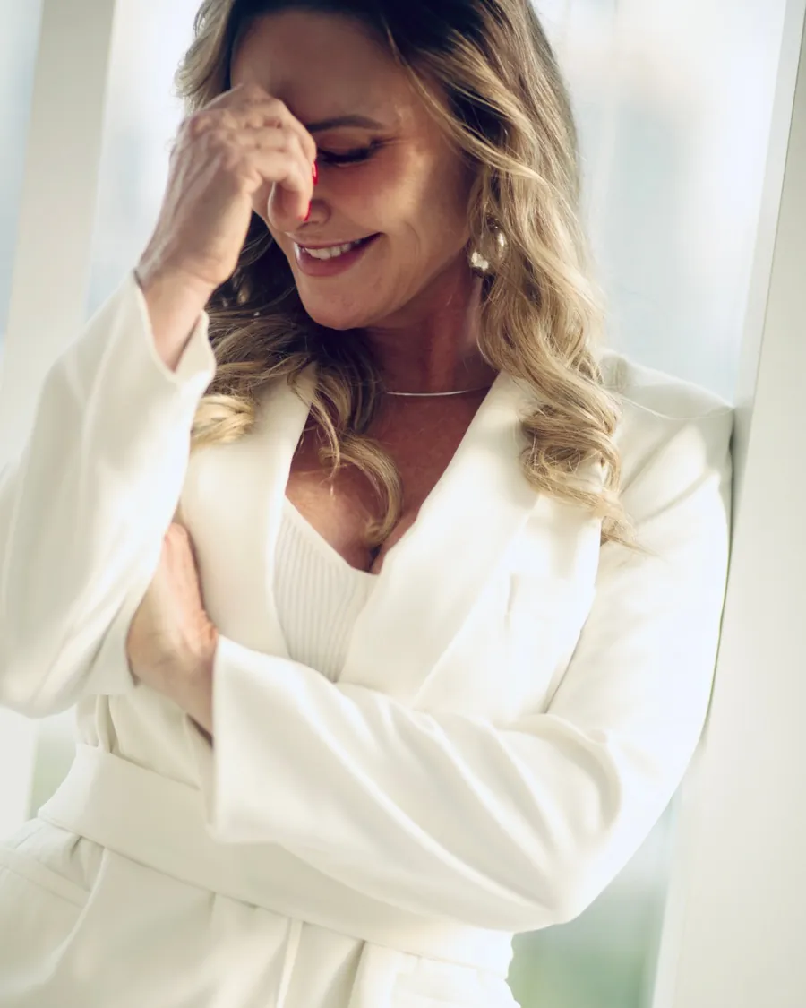 Patrícia Sivieri rindo, de terninho branco