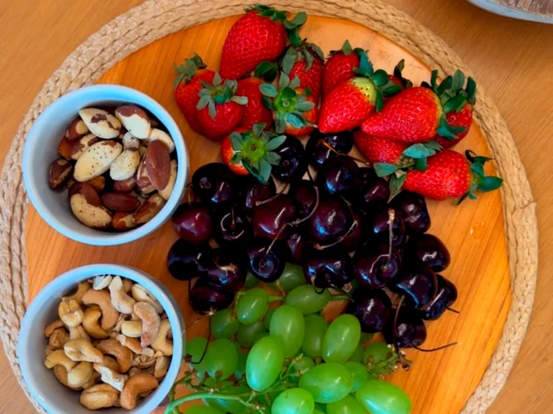 Tábua com morangos, cerejas, uvas, castanhas-do-pará e castanhas-de-caju